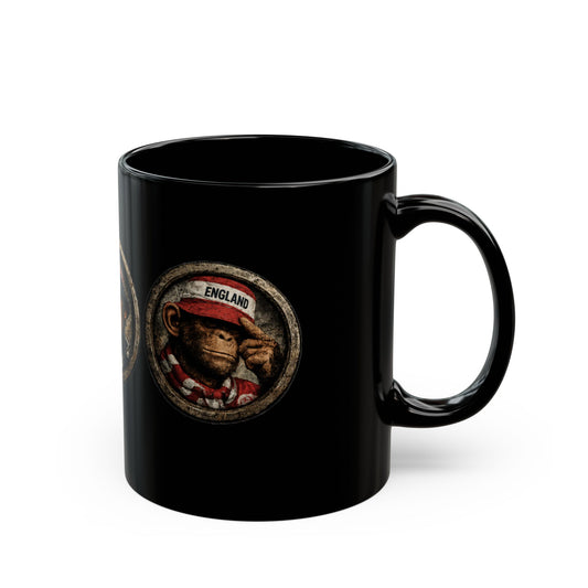 A black ceramic mug features three circular, stone-textured portrait emblems. The central emblem showcases a chimpanzee with a stern expression, wearing a navy blue casual jacket and a navy bucket hat with red and white stripes. The left emblem shows a monkey wearing an England St. George's cross bucket hat and a blue-and-white bar scarf. The right emblem shows a monkey in a red casual cap and scarf.