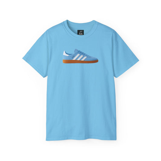 Light blue t-shirt with a graphic of a blue sneaker with white stripes and gum sole on front