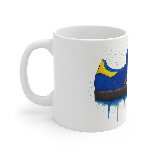 White ceramic mug with blue and yellow sneaker illustration and paint splatter design