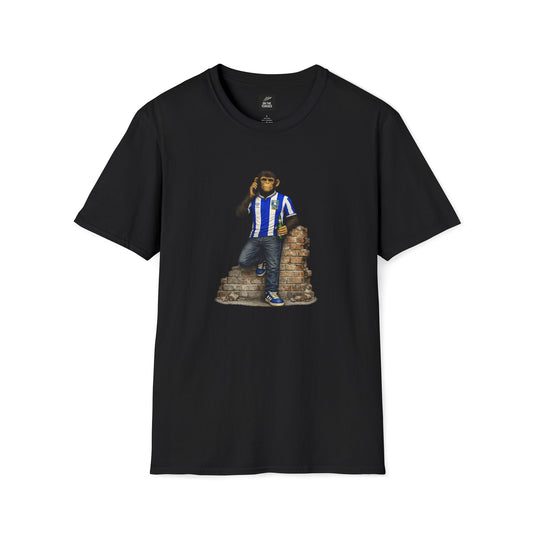 A black t-shirt with a graphic of a single chimpanzee wearing a blue and white striped Sheffield Wednesday football kit, blue trainers, and jeans, leaning against a small brick wall while holding a green bottle and talking on a mobile phone.