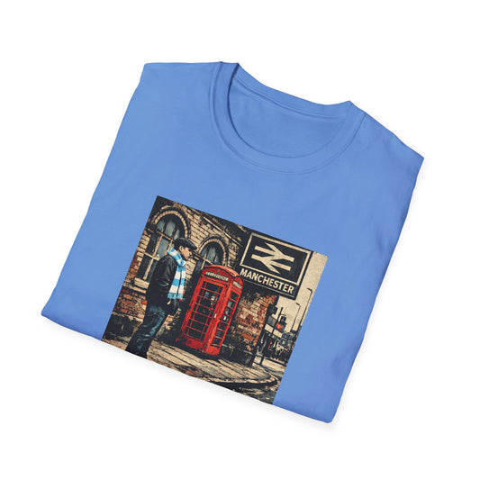 Folded blue t-shirt with a graphic of a man, red phone booth, and 'Manchester' sign.