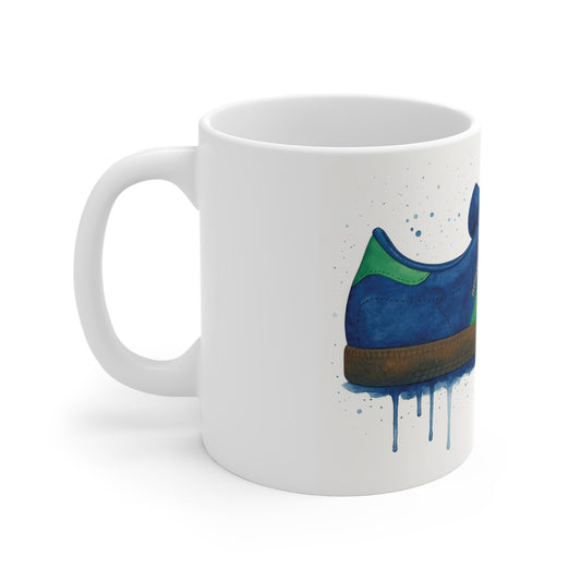 White ceramic mug with artistic blue and green sneaker illustration and paint drip effect