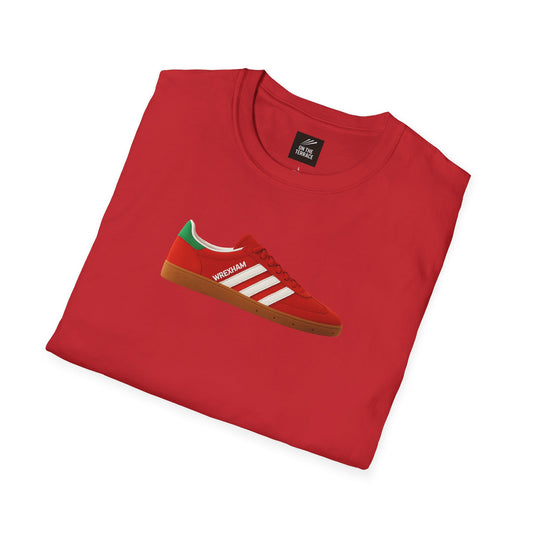 Red folded t-shirt featuring a red sneaker graphic with white stripes and green heel detail, labeled Wrexham
