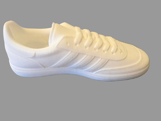 White adidas manchester sneaker on a textured gray surface