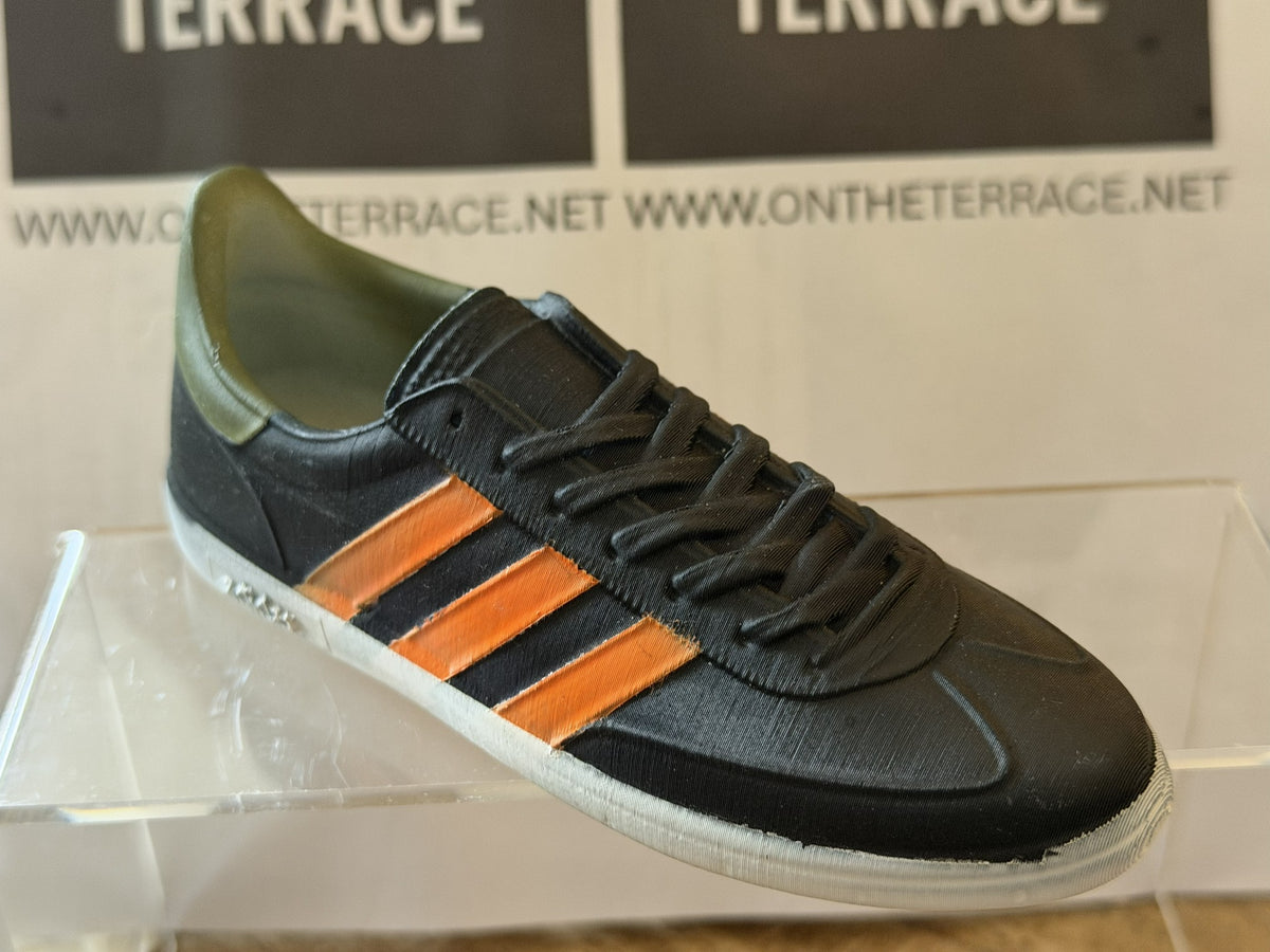 Angled view of painted black and orange Spezial inspired miniature trainer