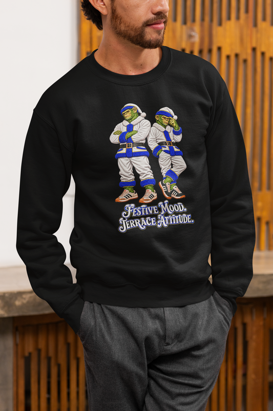 Man in grey trousers wearing the black Leeds United Christmas jumper with white Santa chimps and Festive Mood Terrace Attitude slogan
