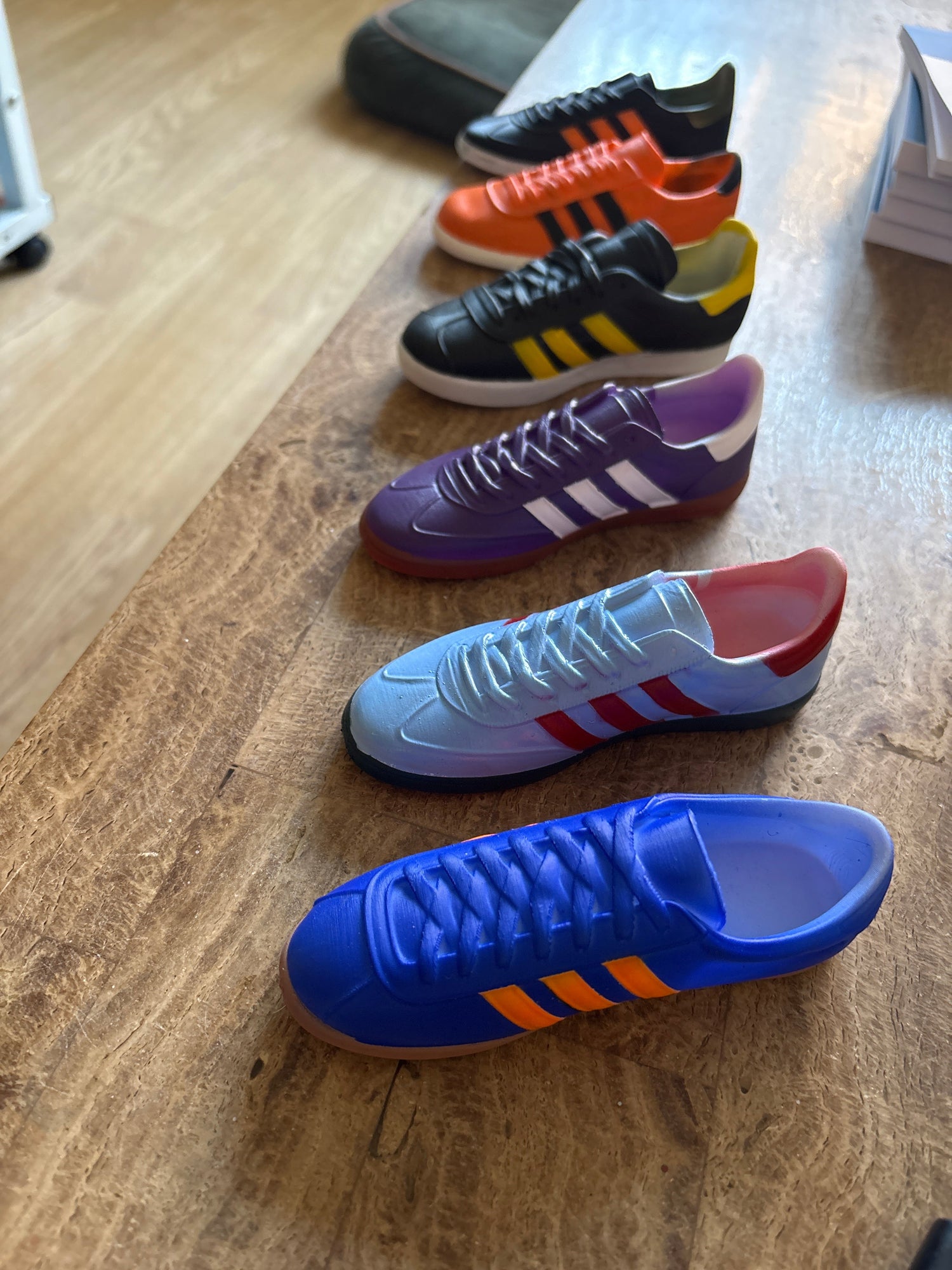 Colorful casual trainer sneakers in various styles arranged on wooden table, football-inspired design