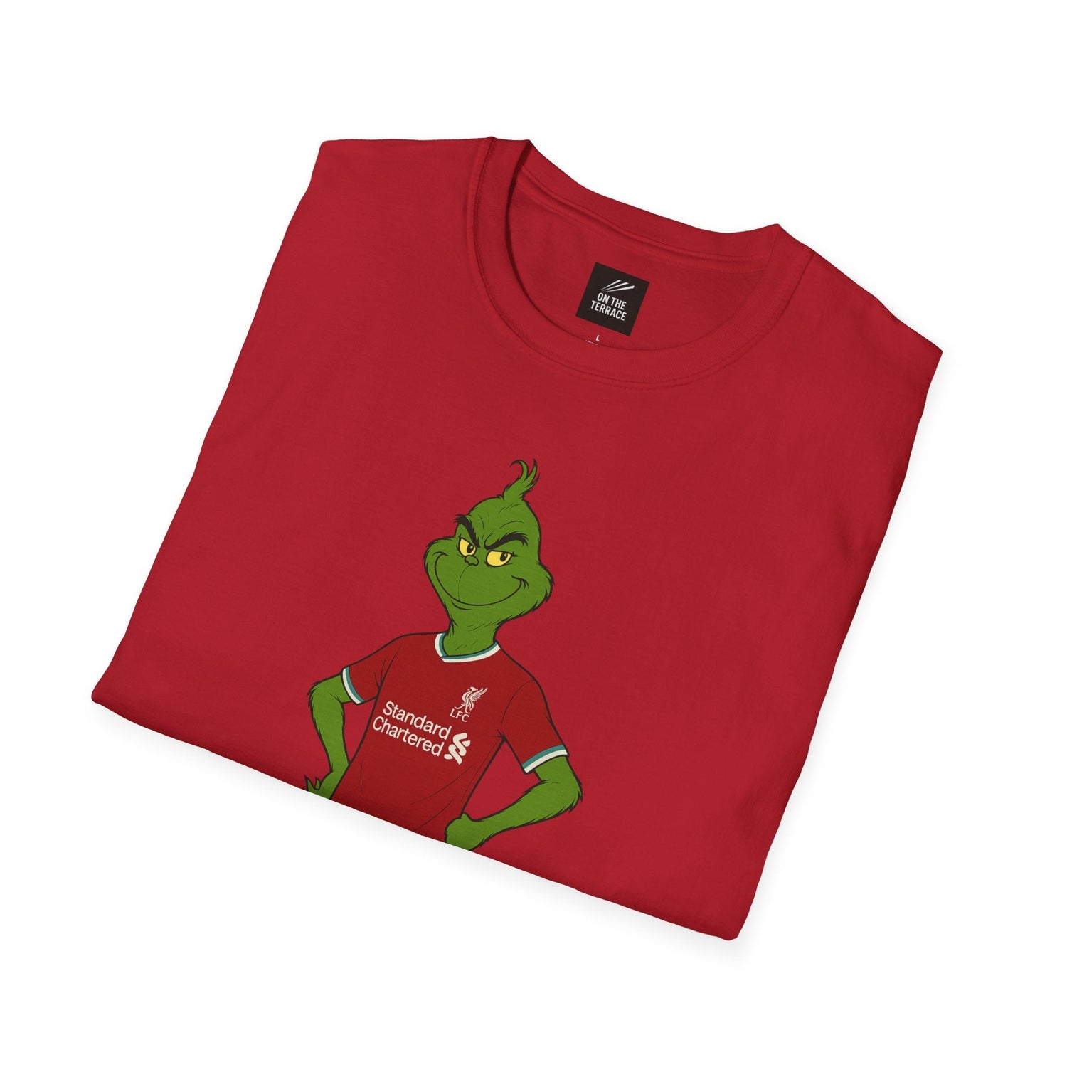 Red folded t-shirt featuring the Grinch wearing a Liverpool FC jersey with Standard Chartered sponsor logo