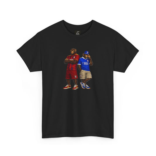 A black short-sleeve Ipswich t-shirt featuring a graphic print of two men standing side-by-side. The man on the left wears a red jersey and shorts, while the man on the right wears a blue jersey and khaki shorts.