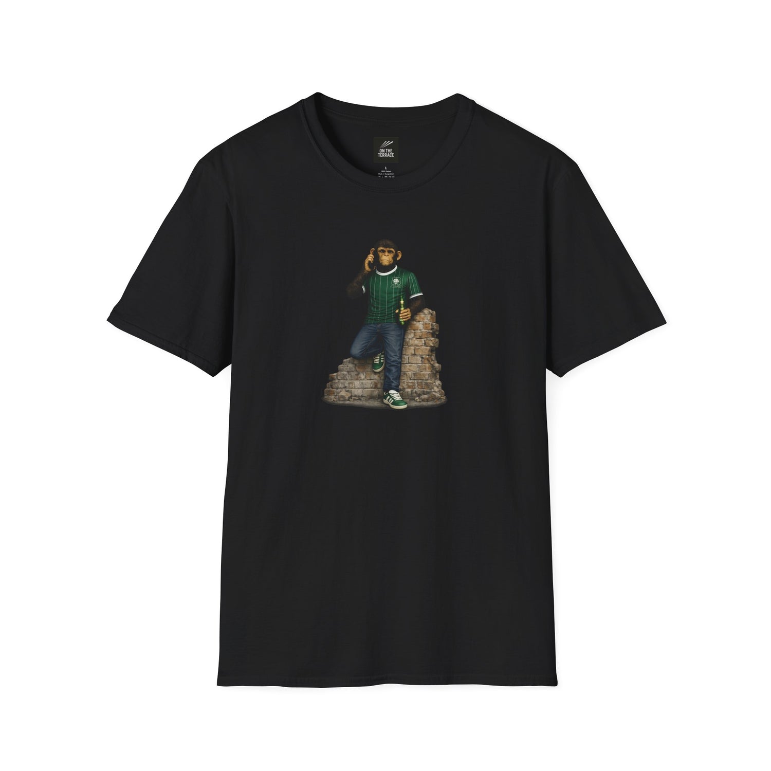 A black t-shirt featuring a chimpanzee wearing a green and white pinstriped football jersey and green trainers, leaning on a brick wall while using a mobile phone.