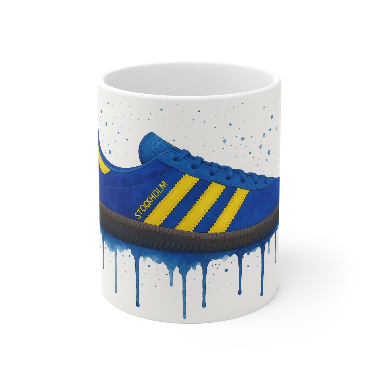 White coffee mug featuring blue and yellow Adidas Stockholm sneaker graphic with paint drip effect