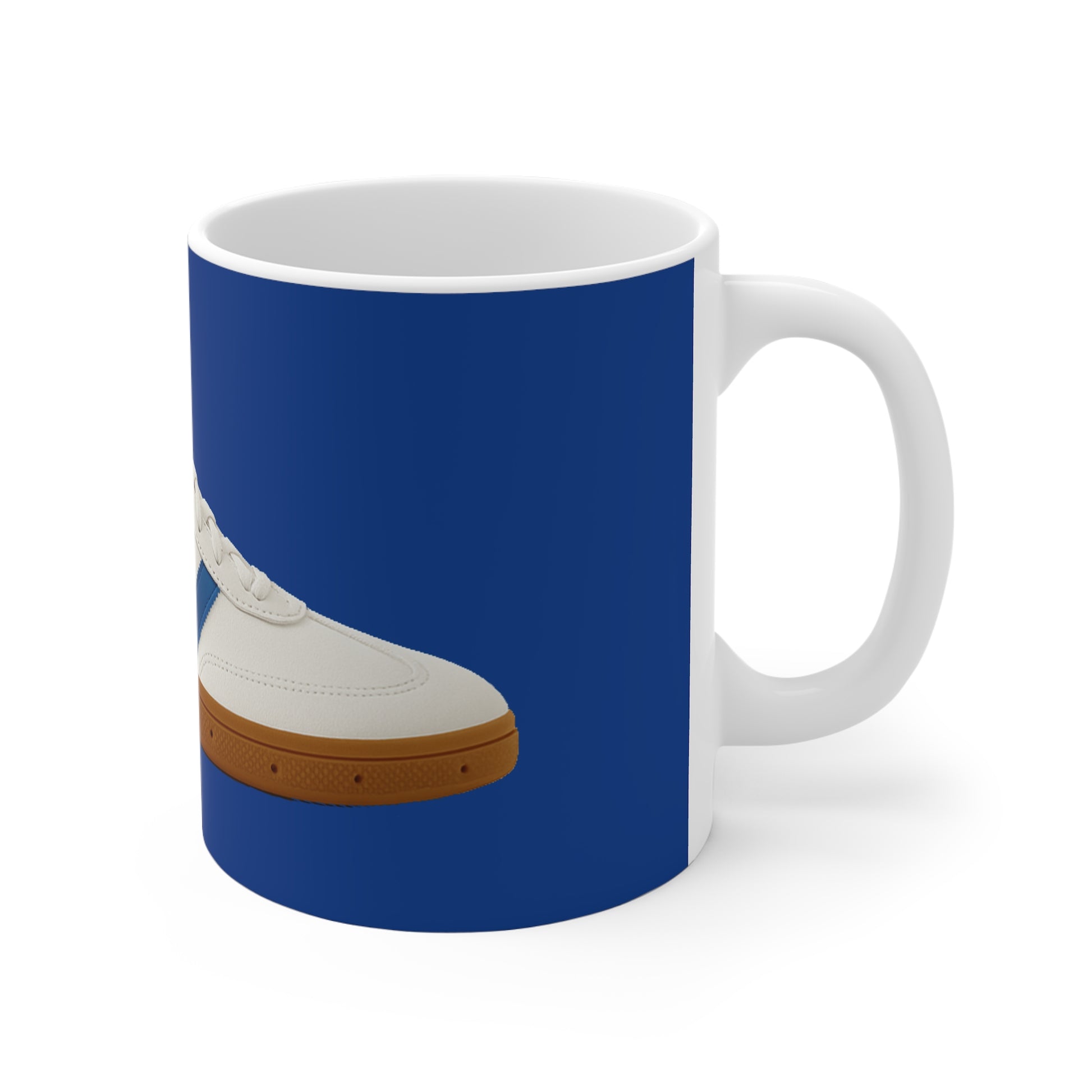 White ceramic mug with blue background featuring a white sneaker with brown sole design