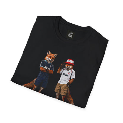 A black graphic t-shirt laid flat, featuring a central design by On The Terrace for Bolton fans. The graphic showcases two anthropomorphic English foxes dressed in vintage Rbk Bolton-inspired football kits. The fox on the left wears the dark blue retro away jersey with arms crossed, while the fox on the right sports the classic white home shirt, a red and white bucket hat, and cargo shorts. The inner neck of the tee features the official "On The Terrace" brand logo