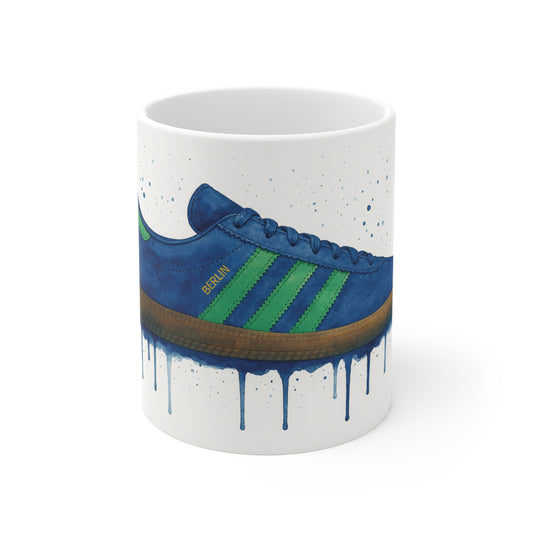 White mug with watercolor-style blue and green sneaker design labeled Berlin with paint drip effect