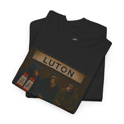 A folded black crewneck Luton t-shirt featuring a graphic print of the Three Stooges in a Luton bus scene under a 'LUTON' sign, displayed on a clean white background.