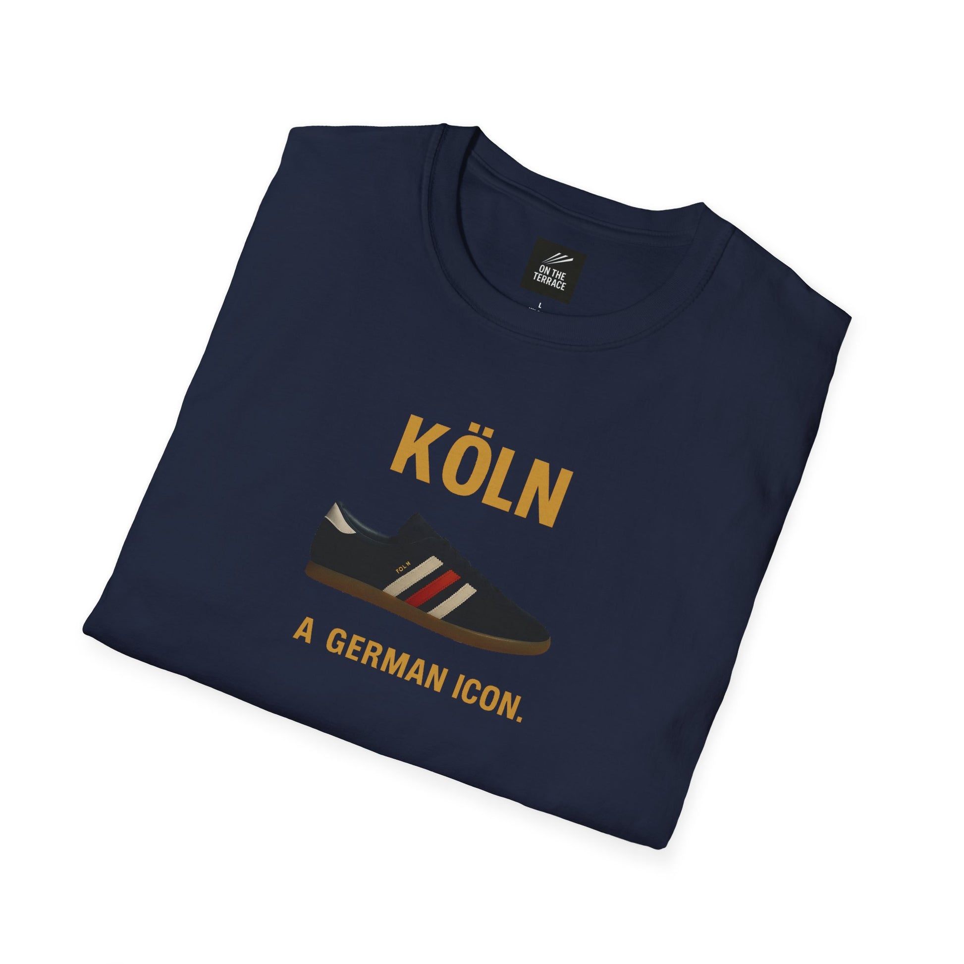 Folded navy blue t-shirt with yellow text Köln and a graphic of a black sneaker with red and white stripes