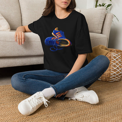 Person wearing a black t-shirt with hand-illustrated blue and orange retro terrace trainer sneaker graphic print, On The Terrace casual clothing brand
