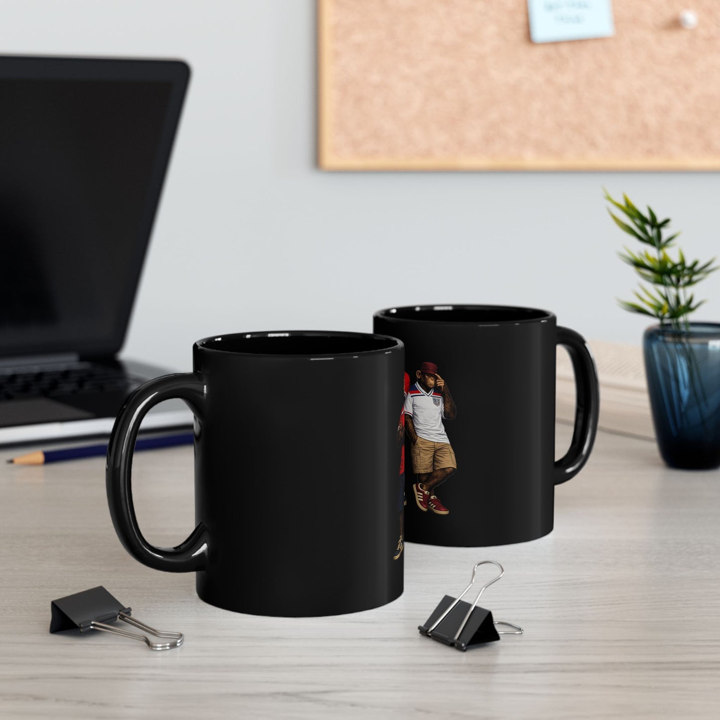 The cup shows an 11oz black ceramic mug featuring a graphic of two chimpanzees dressed in vintage England football casual attire. The monkey on the left is wearing a retro red away kit with dark blue shorts and navy trainers. The monkey on the right wears a vintage white home kit, a maroon cap, tan shorts, and red terrace-style trainers. Both characters stand against a solid black background.