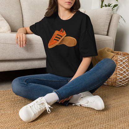 Black t-shirt with orange retro sneaker graphic print showing side and sole view