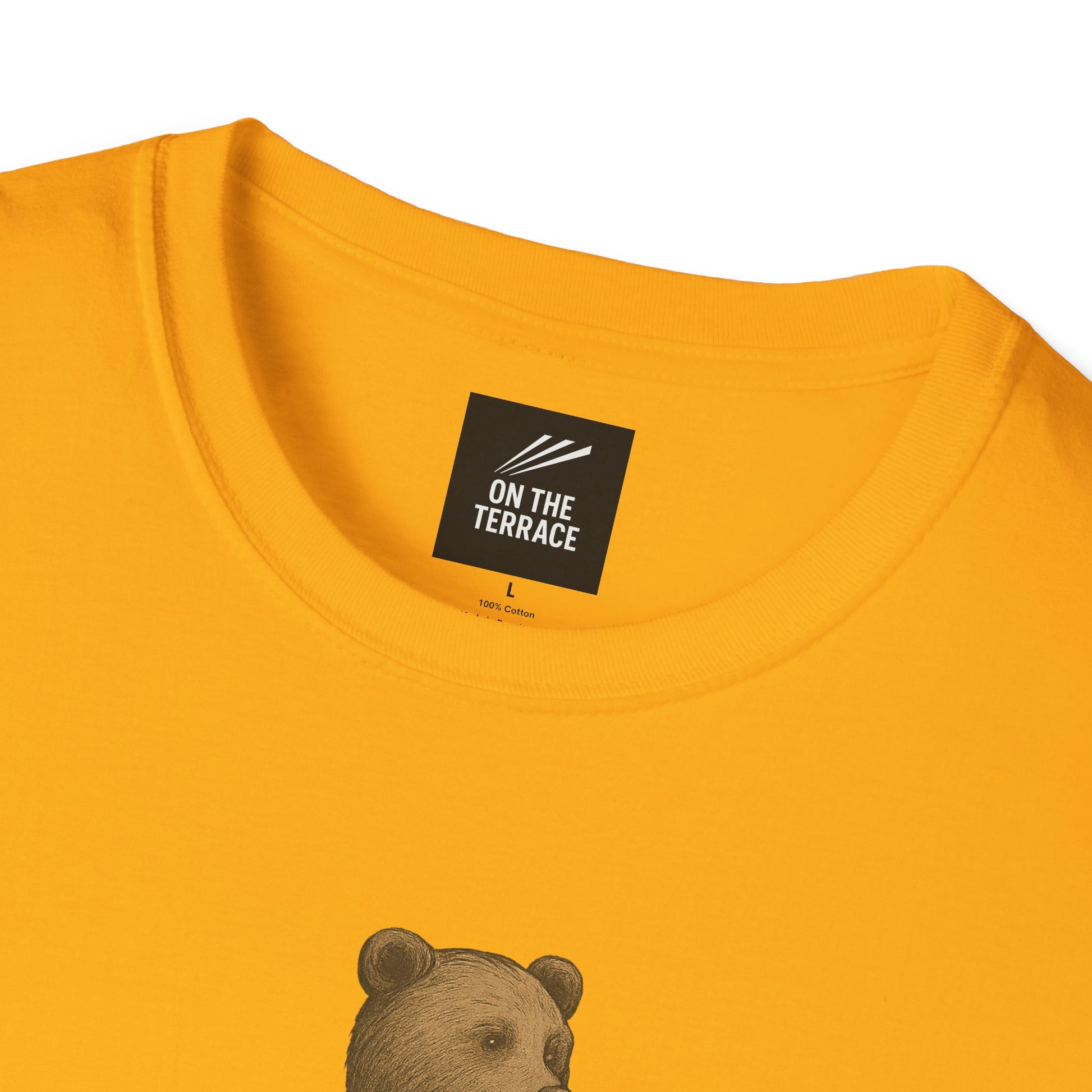 Close-up of yellow cotton T-shirt collar with black On The Terrace label and bear graphic