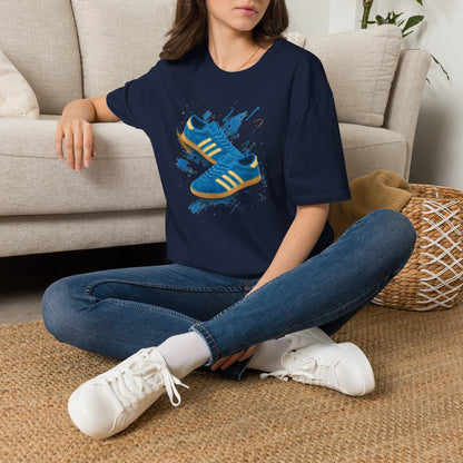 Navy blue t-shirt with a printed graphic of a blue suede trainer featuring cream stripes and a gum sole, surrounded by a blue and gold paint splatter design, with an "On The Terrace" logo on the neck label.