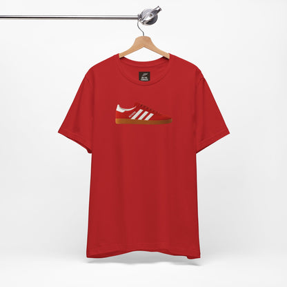 Red t-shirt with printed image of red sneaker with white stripes and gum sole hanging on metal hanger