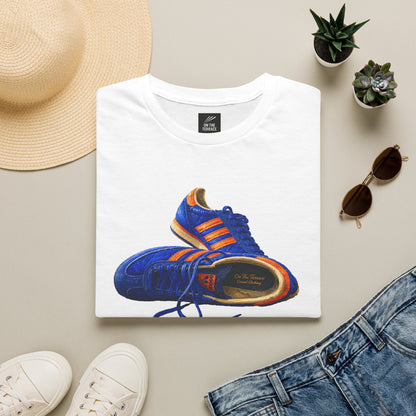 White t-shirt with illustration of blue and orange adidas Gazelle-style trainers, terrace casual sneaker graphic tee, vintage trainer collection, On The Terrace