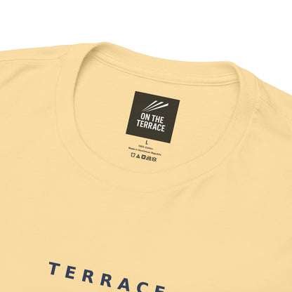 Close-up of the On The Terrace neck label and Terrace Code print on the pale yellow tee