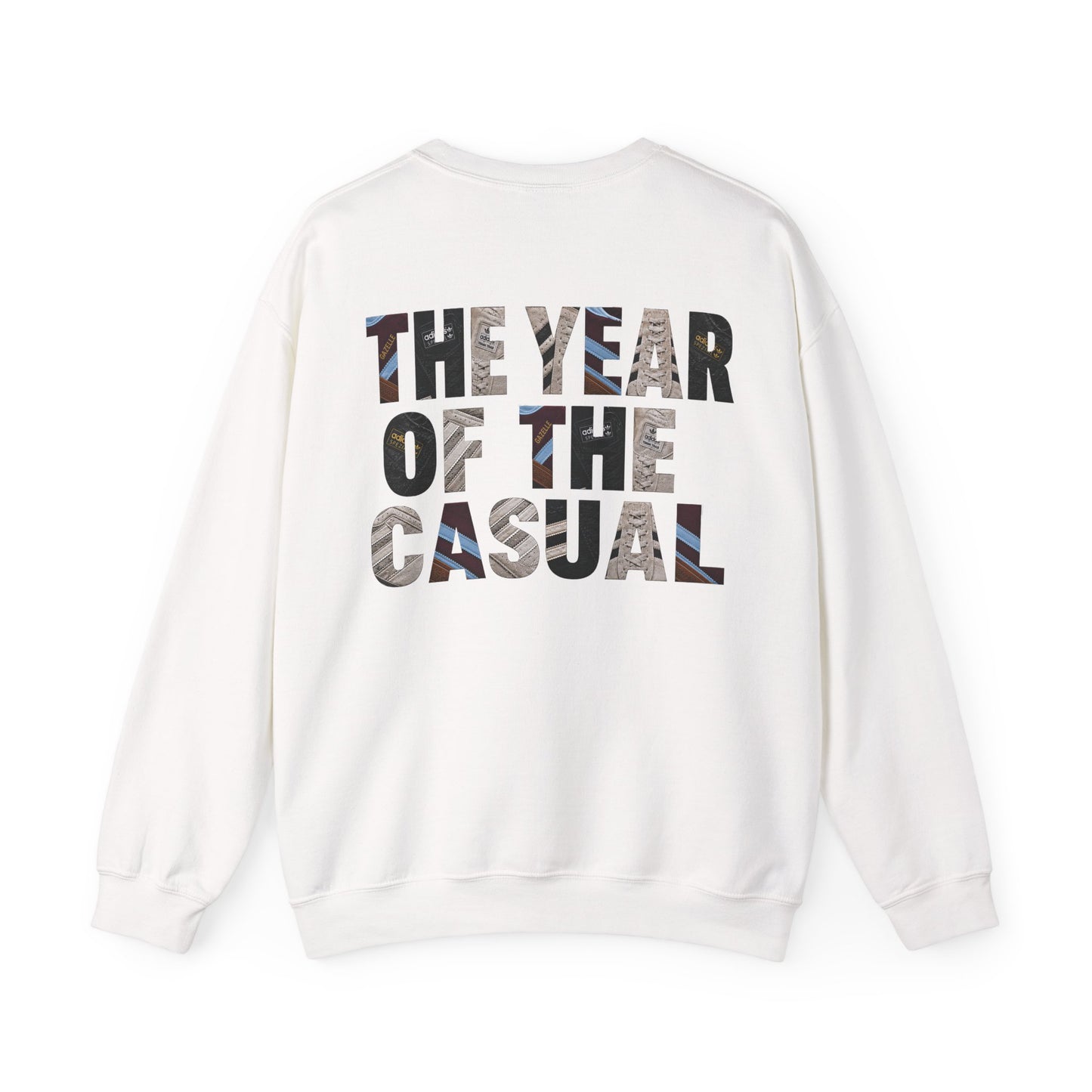 A white crewneck sweatshirt shown from the back, featuring the text 'THE YEAR OF THE CASUAL' printed in a bold, multi-colored camouflage pattern.