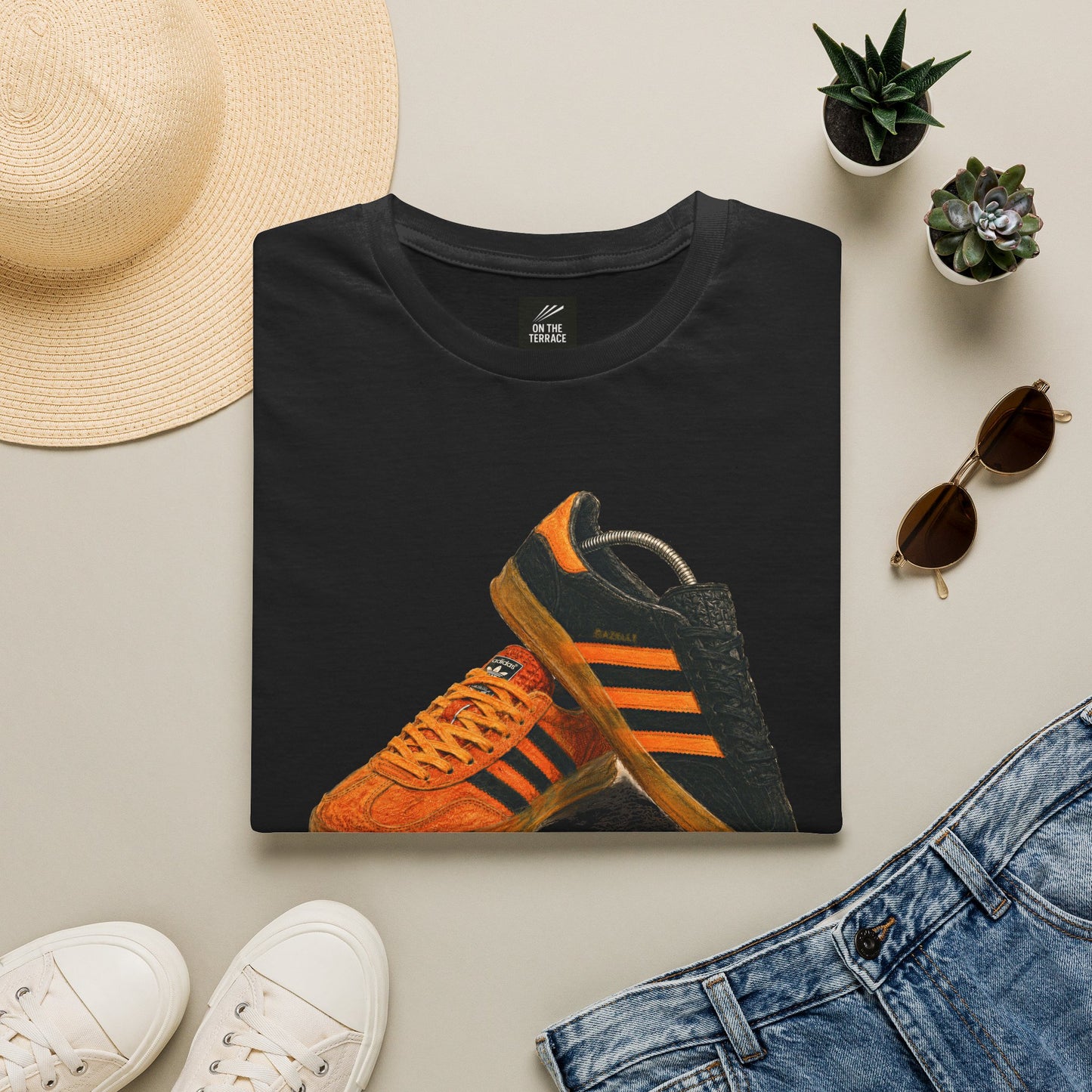 Black t-shirt with orange retro sneaker graphic print showing detailed side and sole view
