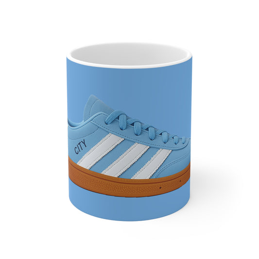 Blue ceramic mug featuring a detailed image of a blue sneaker with white stripes and brown sole on a blue background