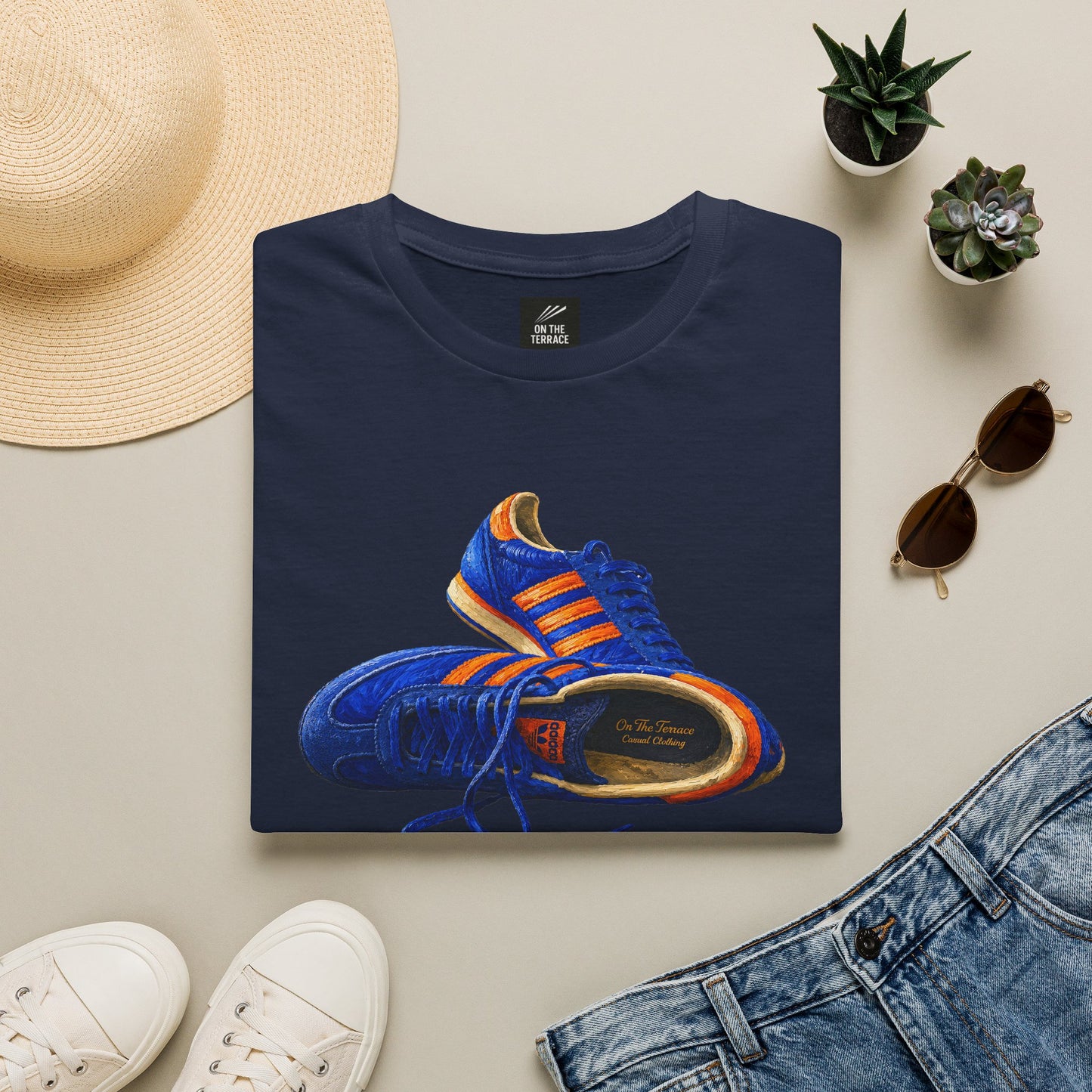 Navy t-shirt with hand-illustrated blue and orange retro terrace trainer sneaker graphic print, On The Terrace casual clothing brand

