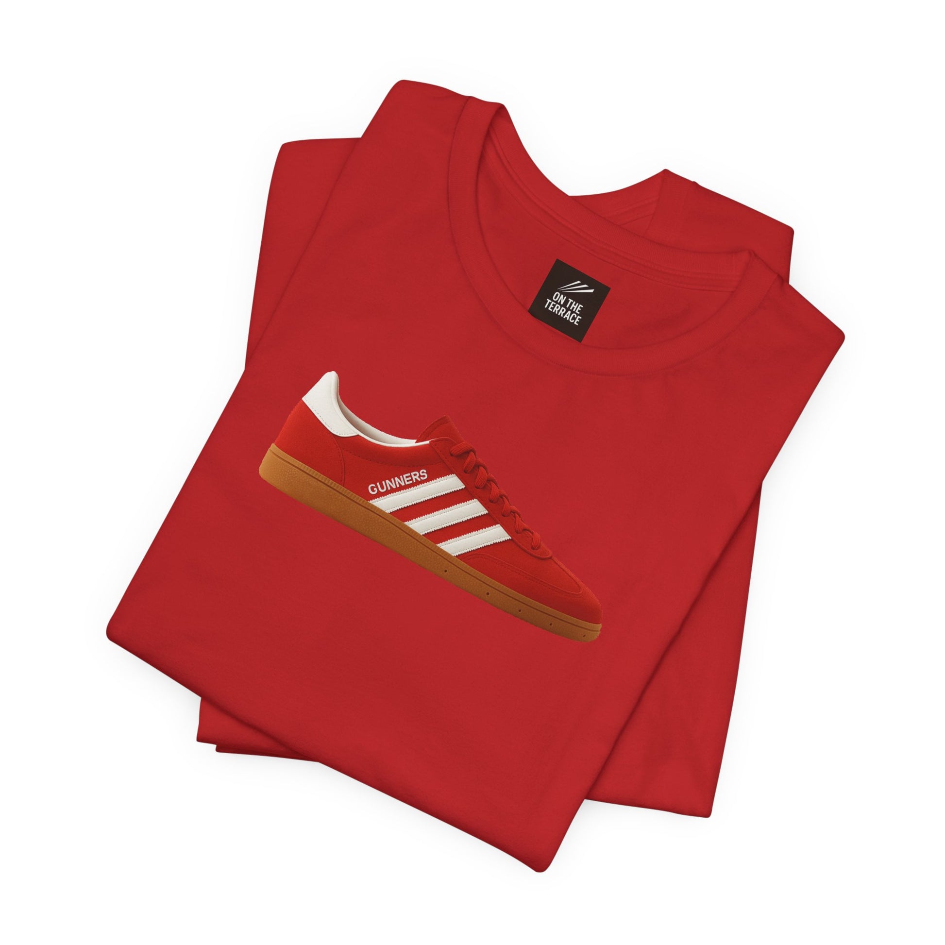 Red folded t-shirt with a graphic of a red sneaker labeled Gunners on the front