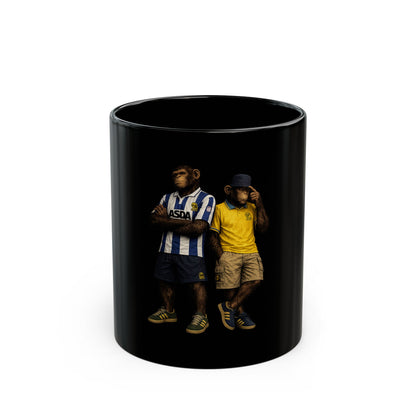 A black ceramic coffee mug featuring a detailed graphic print, showing two chimpanzees dressed in retro Sheffield Wednesday football kits; one wears the blue-and-white striped ASDA home shirt, and the other wears a yellow away shirt with a navy bucket hat.