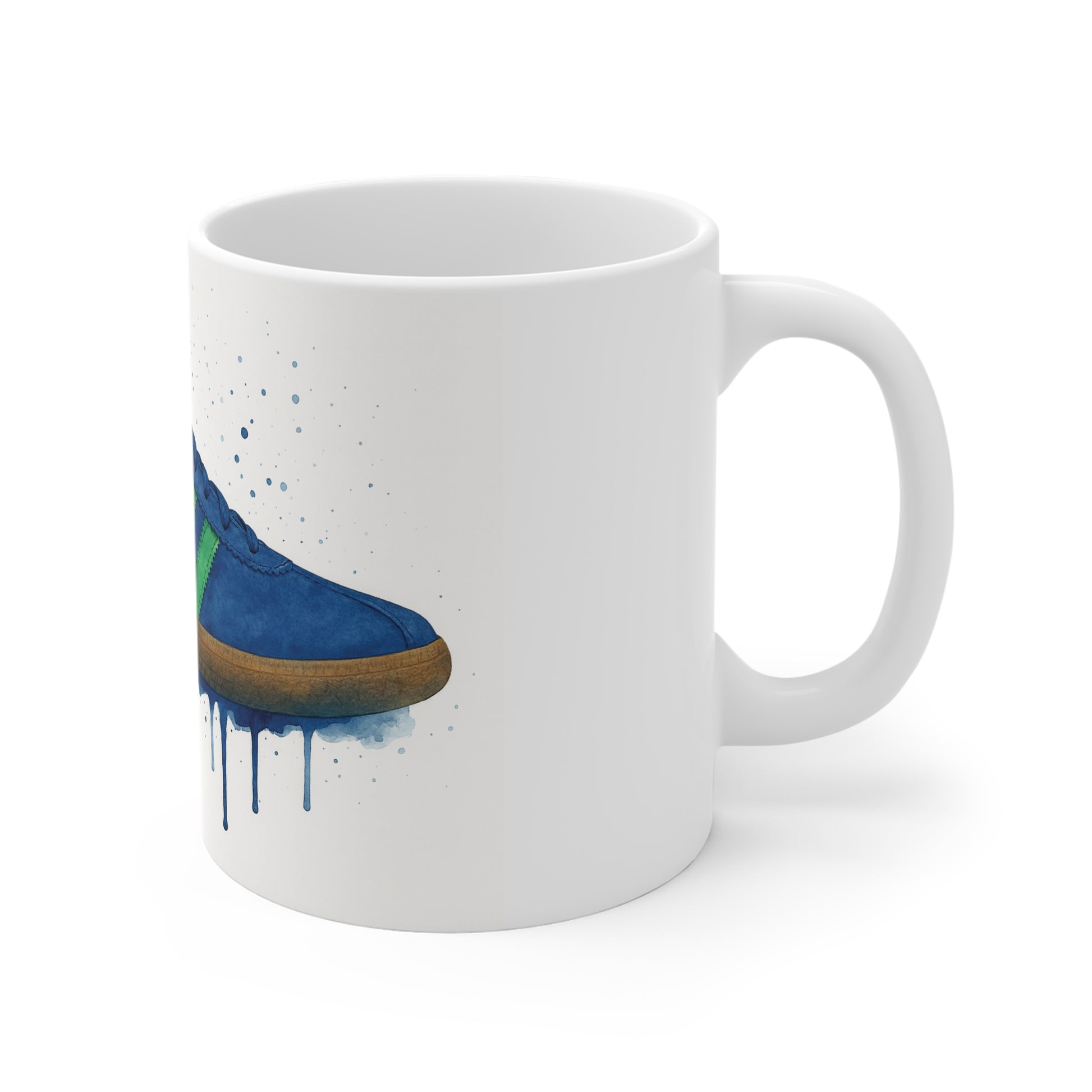 White ceramic mug with blue sneaker and green stripe watercolor design and paint splatters