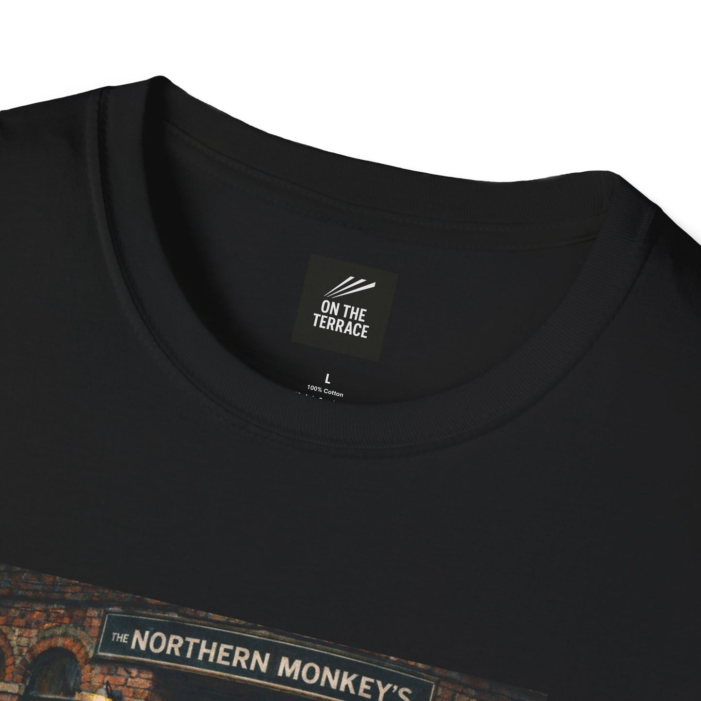 A neatly folded black t-shirt resting on a white surface. The fold highlights the "THE NORTHERN MONKEY'S" pub graphic on the chest and clearly displays the "ON THE TERRACE" brand label inside the neckline.