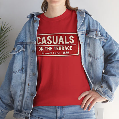 A person wearing a red SUFC T-shirt under an open light-wash denim jacket, with the shirt reading 'CASUALS ON THE TERRACE Bramall Lane 1889'.