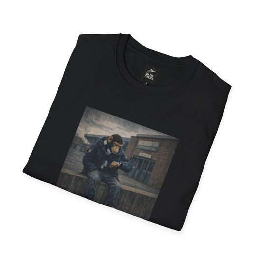 Folded black t-shirt with a graphic of a person sitting on a bench.