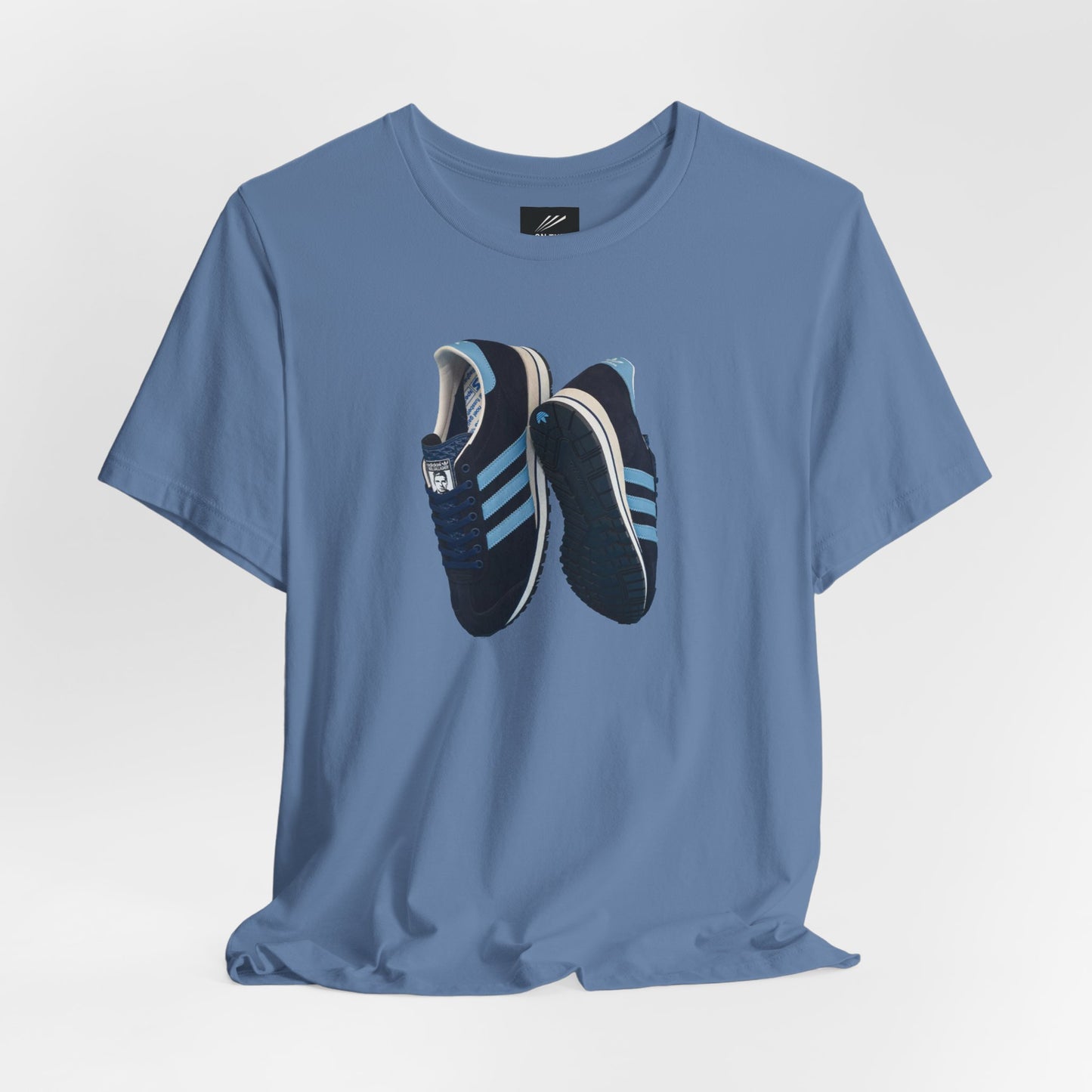 Blue t-shirt with graphic of navy blue Adidas sneakers featuring light blue stripes