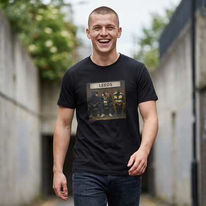 Man wearing a LUFC northern monkeys black t-shirt with 'Leeds' graphic, standing outdoors.