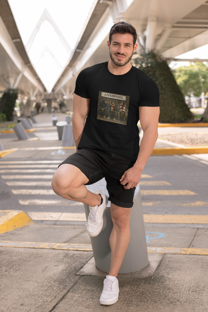 Man posing outdoors wearing a black Black Liverpool LFC northern monkeys t-shirt with 'LIVERPOOL' text on a white backgrond  t-shirt and shorts with a graphic design.