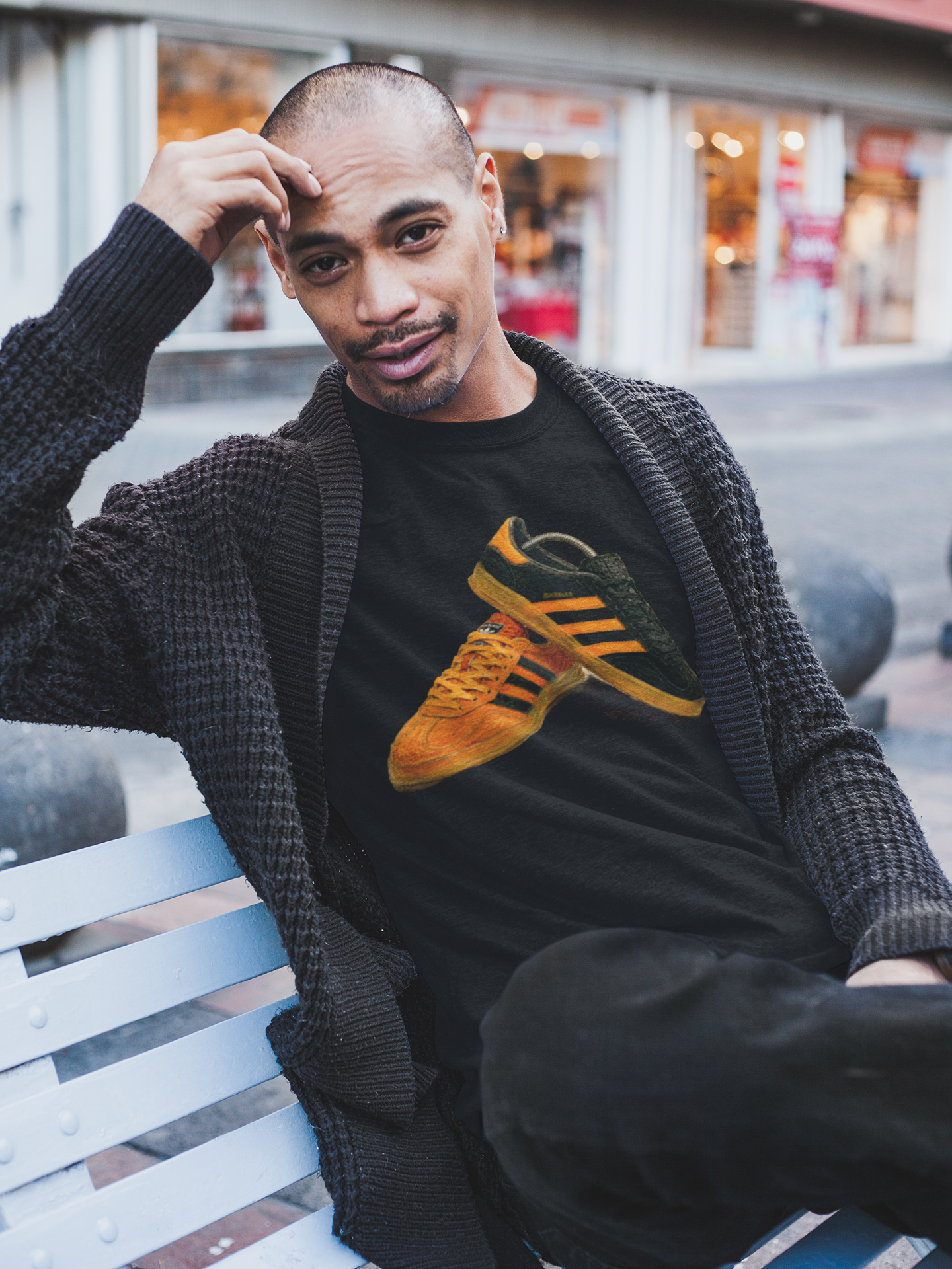 Black t-shirt with orange retro sneaker graphic print showing detailed side and sole view