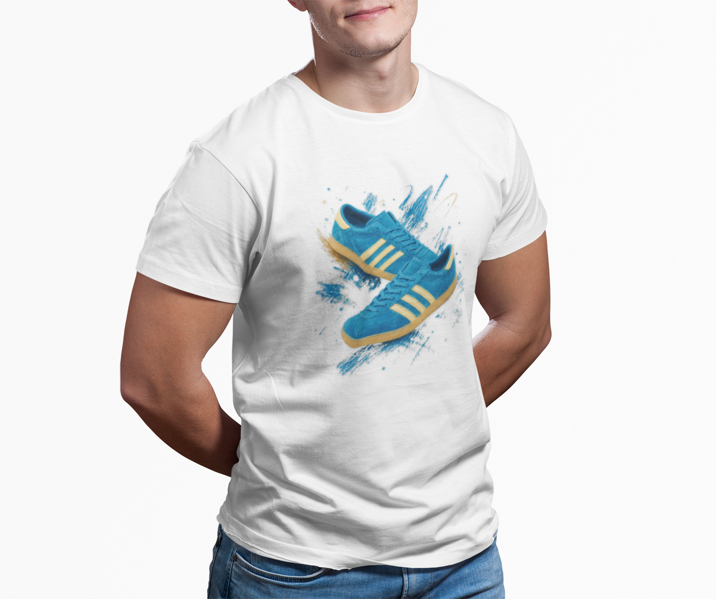 White t-shirt with a graphic print of a blue suede trainer with cream three stripes and gum sole, set against a blue and gold paint-splash background, On The Terrace neck label visible.