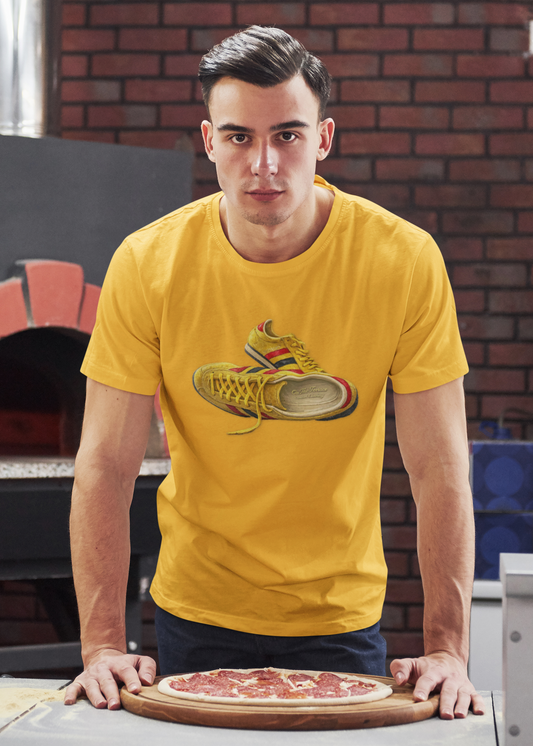 A man wearing a Gold t-shirt with hand-illustrated yellow, navy and red retro terrace trainer sneaker graphic print, On The Terrace casual clothing brand
