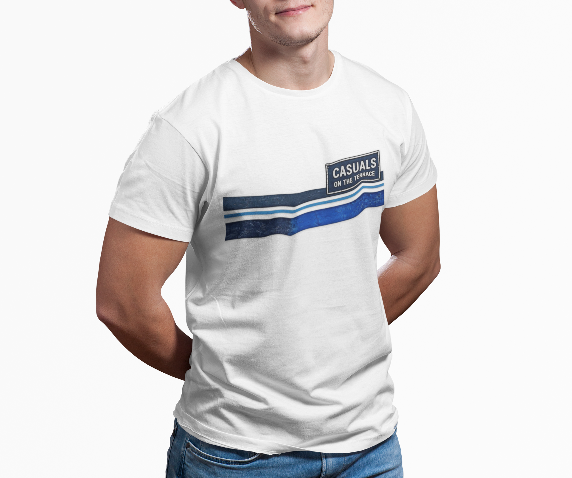A man wearing a white crew-neck t-shirt with a blue graphic stripe design and a small 'CASUALS' logo patch on the chest, paired with blue jeans against a plain white background.