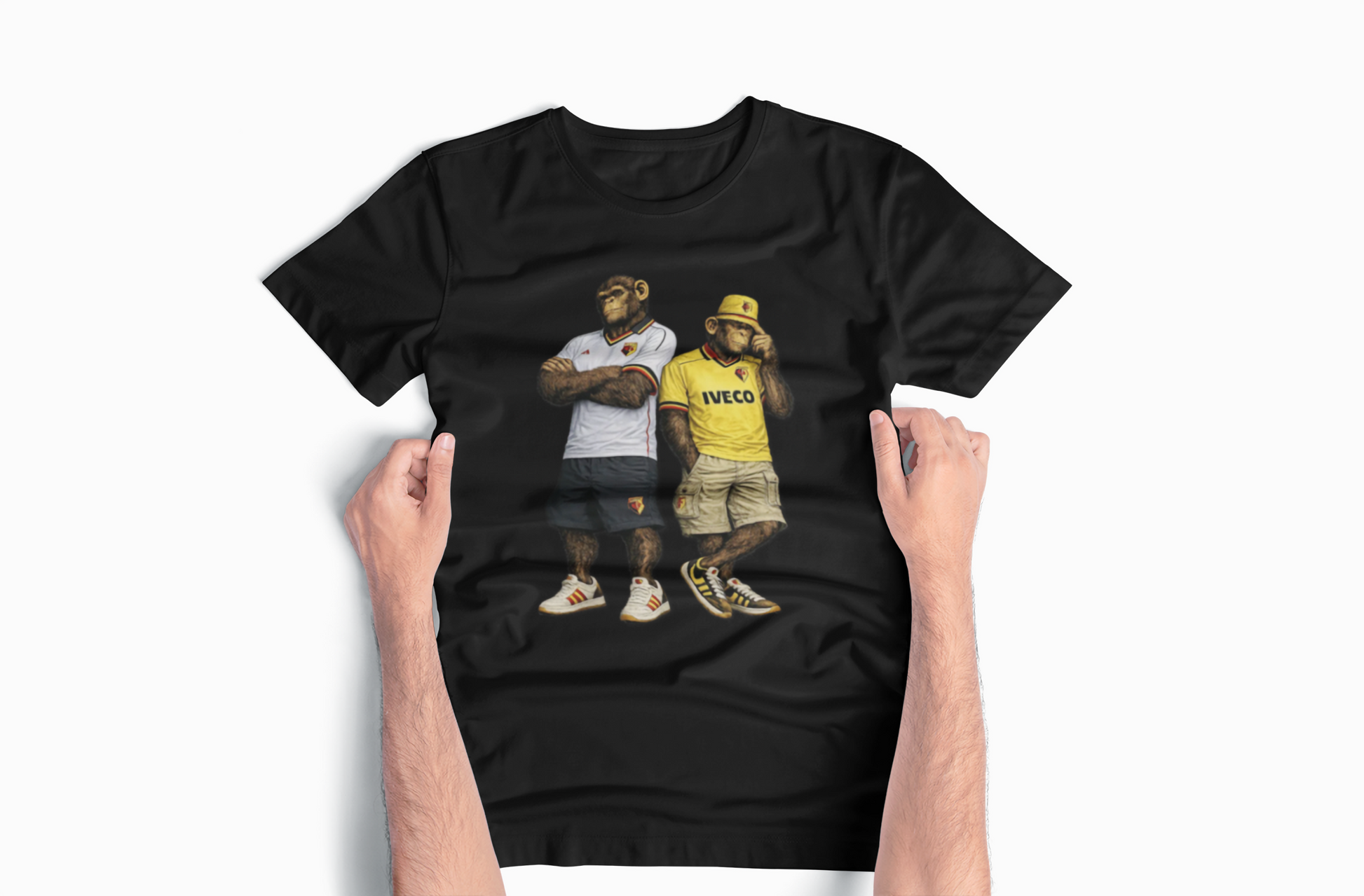 A black short-sleeve Watford t-shirt with a graphic print of two men wearing vintage streetwear, held up by two hands against a light gray background.