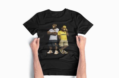 A black short-sleeve Watford t-shirt with a graphic print of two men wearing vintage streetwear, held up by two hands against a light gray background.