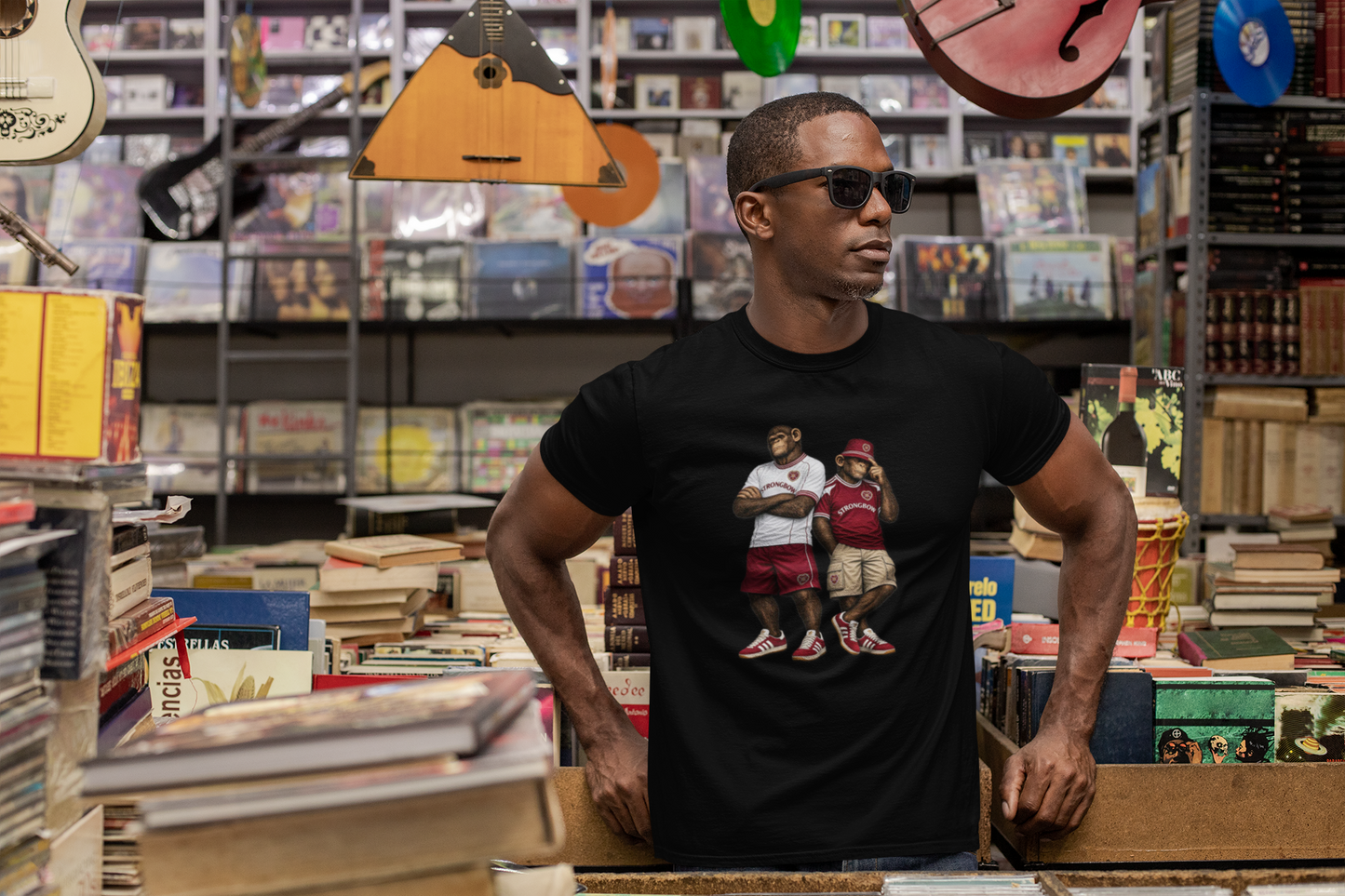 Man wearing a black Hearts t-shirt with 'Motown Detroit' design in a music store.