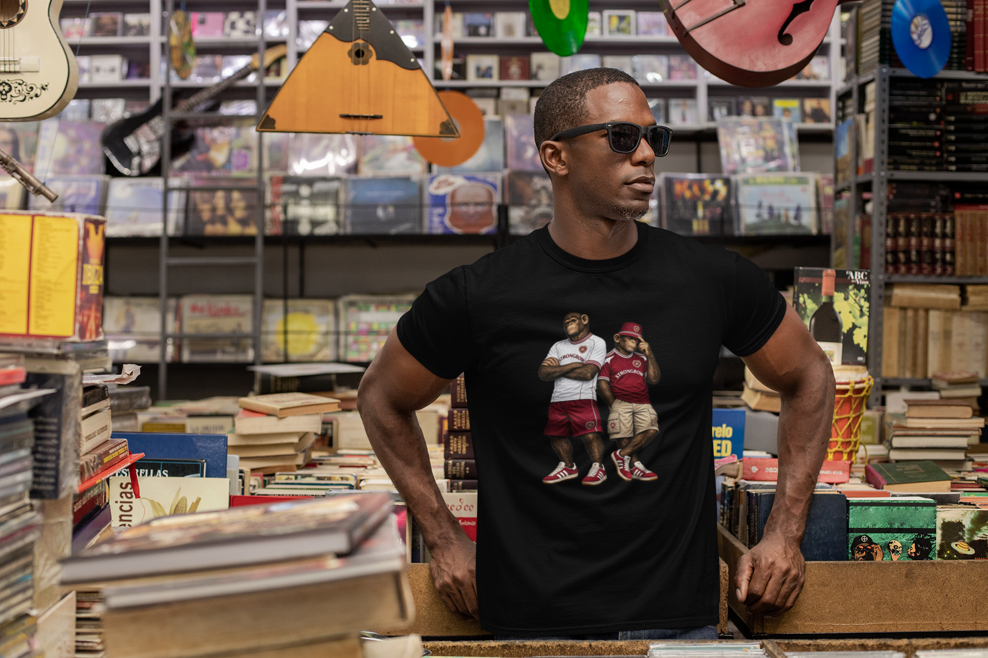 Man wearing a black Hearts t-shirt with 'Motown Detroit' design in a music store.
