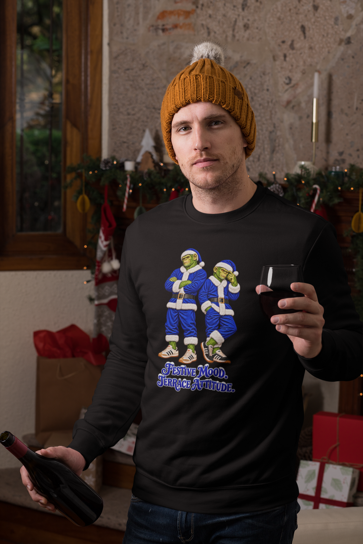 Man in a beanie holding a mug, wearing blue Northern Monkeys Christmas jumper